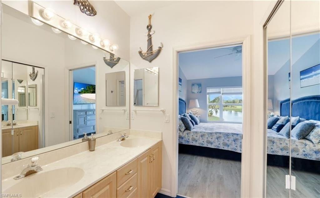 5928 Sand Wedge Lane, Unit 1808 Naples, FL 34110 - Photo 12 of 25 a en suite bathroom with a double vanity sink and a mirror