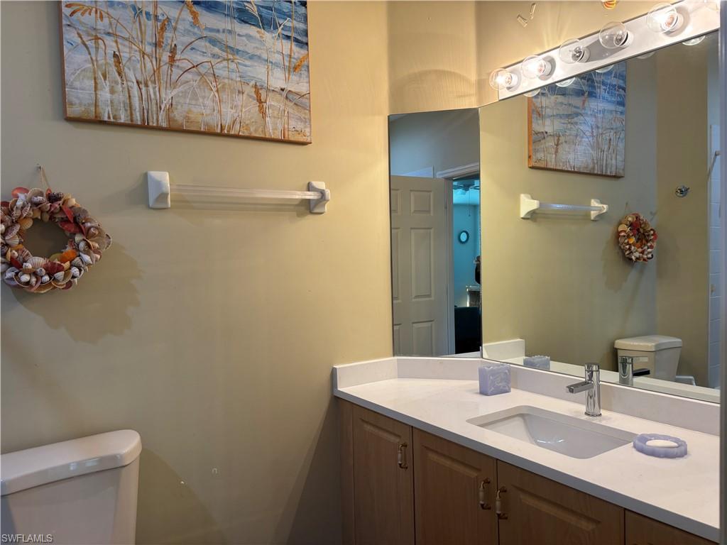 5928 Sand Wedge Lane, Unit 1808 Naples, FL 34110 - Photo 13 of 29 a bathroom with a sink mirror and vanity