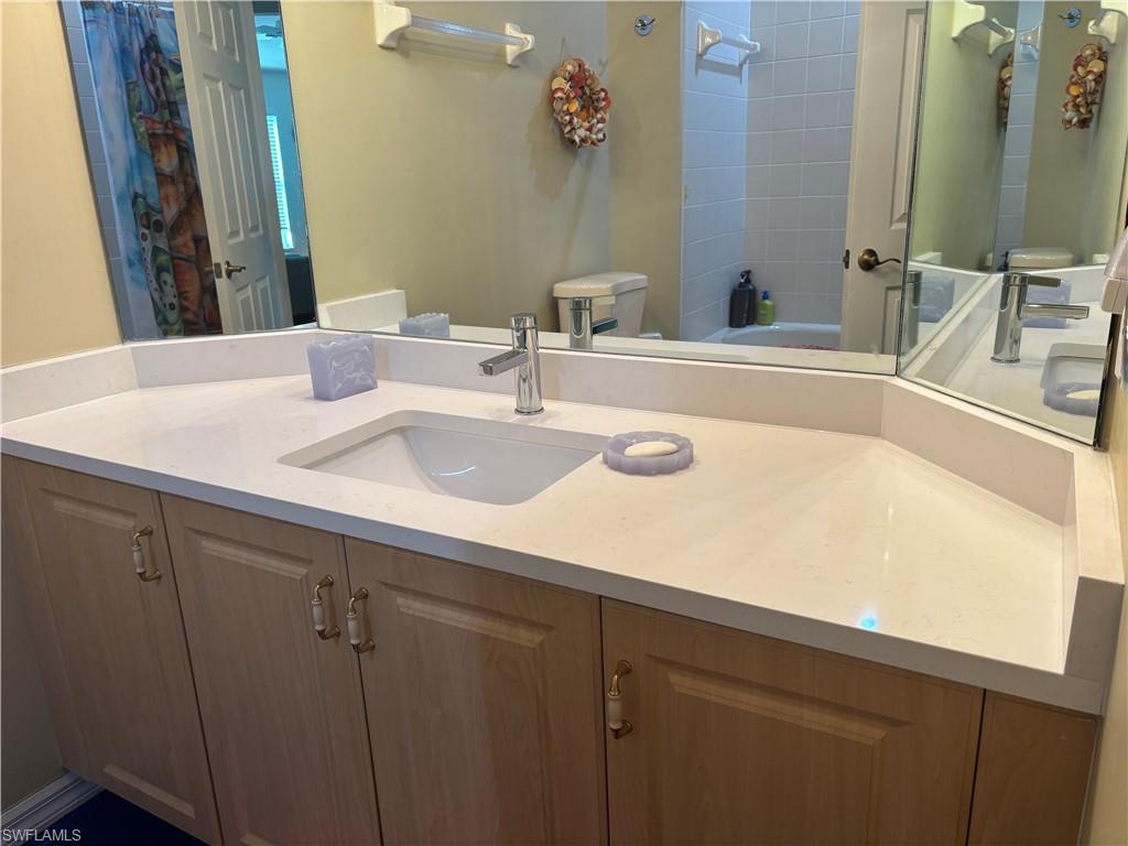 5928 Sand Wedge Lane, Unit 1808 Naples, FL 34110 - Photo 14 of 29 a bathroom with a sink and a mirror