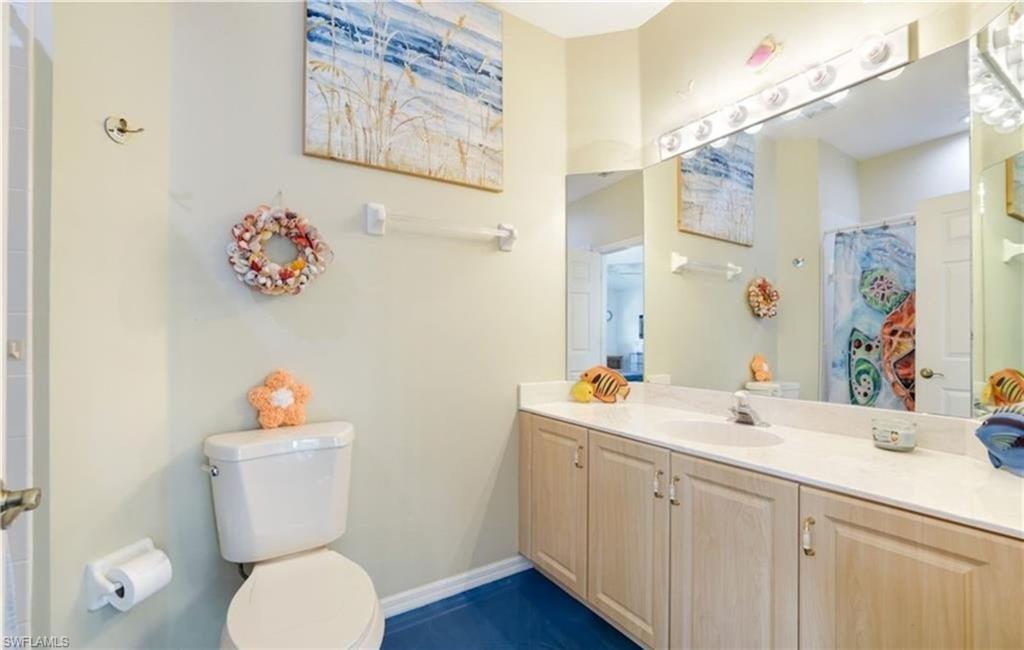 5928 Sand Wedge Lane, Unit 1808 Naples, FL 34110 - Photo 14 of 25 a bathroom with a sink mirror vanity and toilet