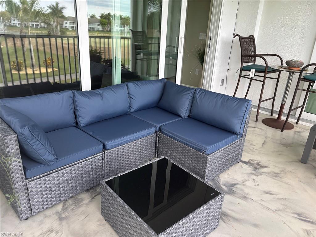 5928 Sand Wedge Lane, Unit 1808 Naples, FL 34110 - Photo 16 of 29 a living room with furniture and a floor to ceiling window