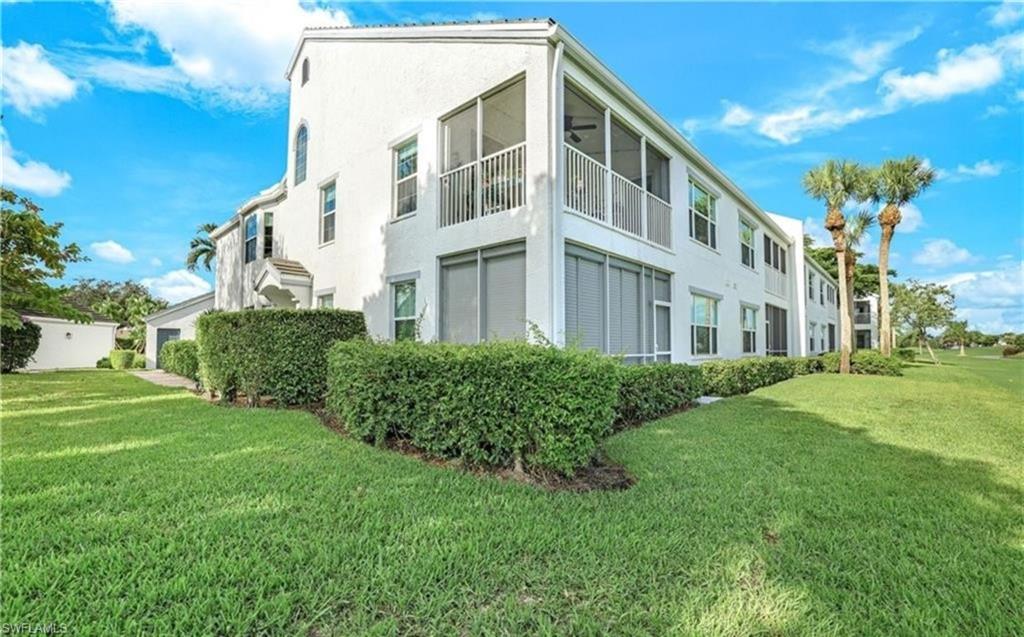 5928 Sand Wedge Lane, Unit 1808 Naples, FL 34110 - Photo 19 of 29 a view of a building next to a big yard