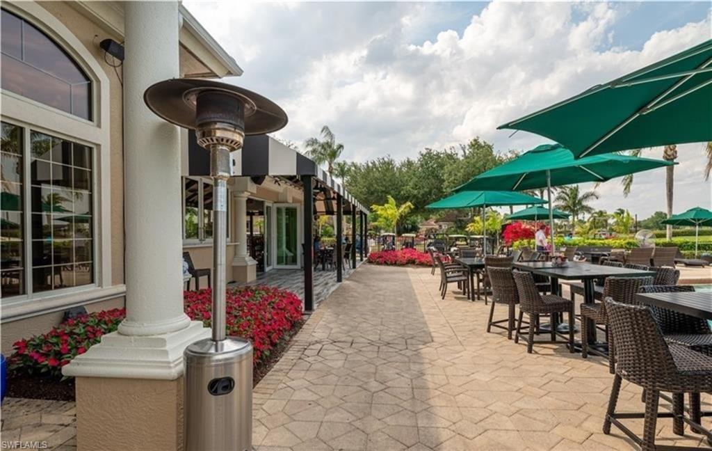 5928 Sand Wedge Lane, Unit 1808 Naples, FL 34110 - Photo 21 of 29 a view of a chairs and table in patio with a barbeque grill