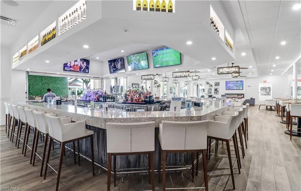 5928 Sand Wedge Lane, Unit 1808 Naples, FL 34110 - Photo 25 of 25 a kitchen with stainless steel appliances kitchen island granite countertop a dining table chairs and a oven