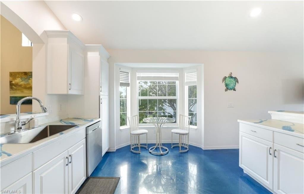 5928 Sand Wedge Lane, Unit 1808 Naples, FL 34110 - Photo 4 of 25 a kitchen with a wooden floor and white cabinets