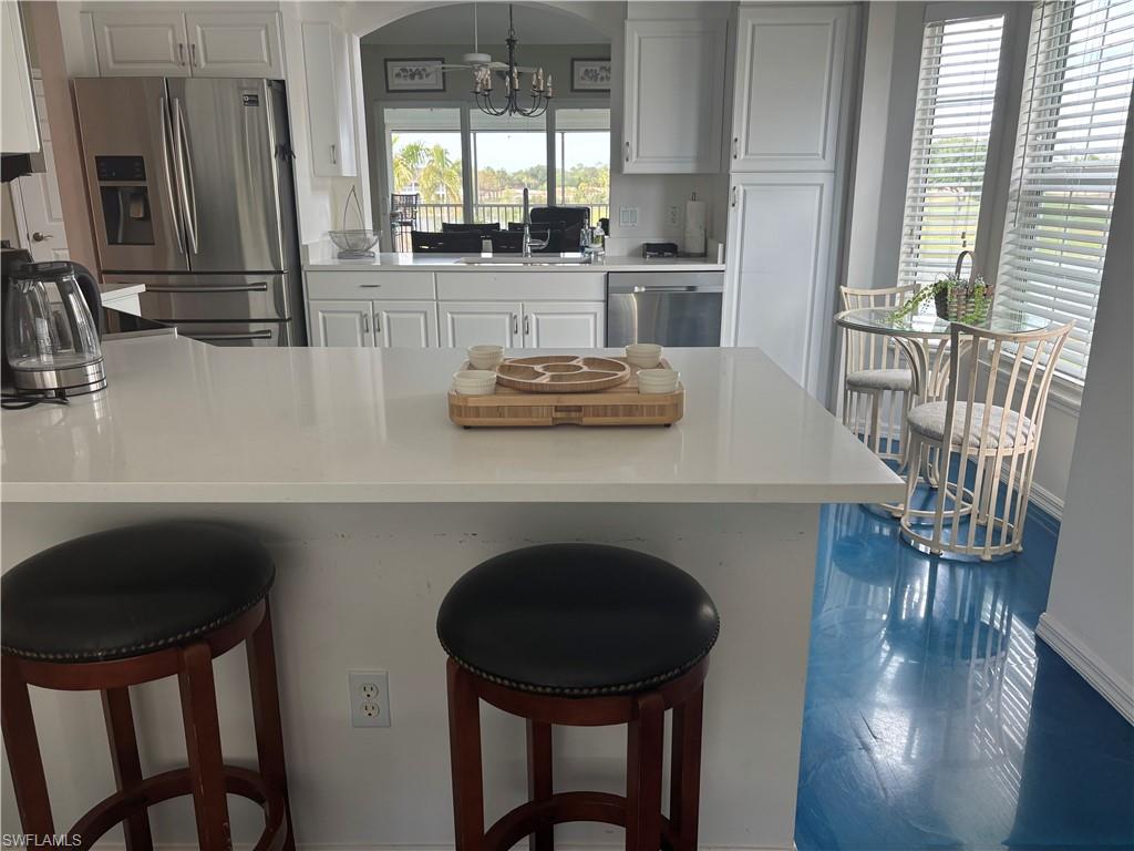 5928 Sand Wedge Lane, Unit 1808 Naples, FL 34110 - Photo 5 of 29 a kitchen with a table chairs stove and wooden floor