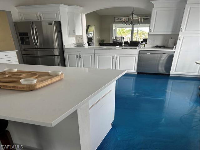5928 Sand Wedge Lane, Unit 1808 Naples, FL 34110 - Photo 6 of 29 a kitchen with kitchen island a stove a sink and a refrigerator