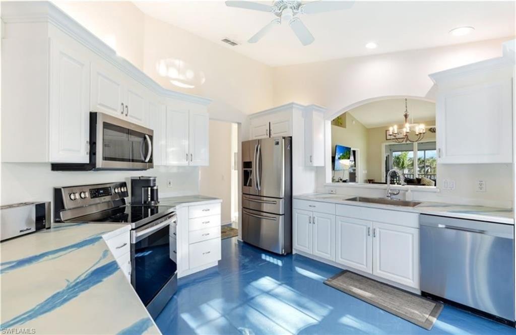 5928 Sand Wedge Lane, Unit 1808 Naples, FL 34110 - Photo 6 of 25 a kitchen with stainless steel appliances a stove a sink and a refrigerator