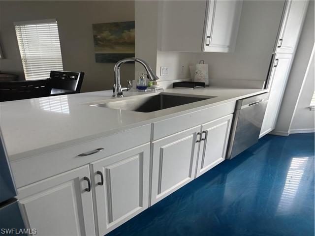 5928 Sand Wedge Lane, Unit 1808 Naples, FL 34110 - Photo 7 of 29 a kitchen with stainless steel appliances granite countertop a sink a stove a microwave a sink and dishwasher with wooden floor