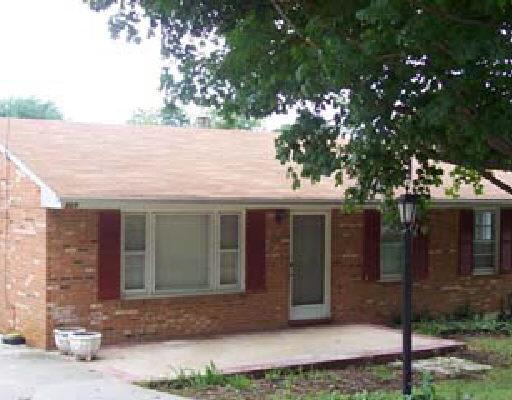 a front view of a house with a tree