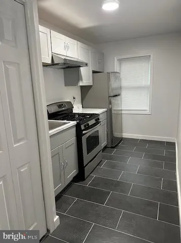 a stove top oven sitting inside of a kitchen