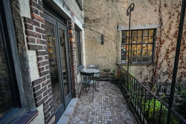 a view of a porch with a table and chairs and floor to ceiling window
