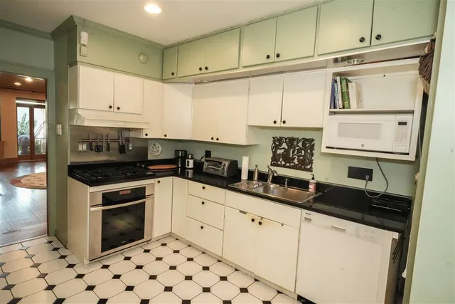 a kitchen with granite countertop a sink a stove and cabinets