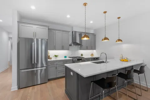 a kitchen with a sink a stove a refrigerator and island