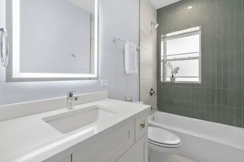 a bathroom with a sink toilet vanity and bathtub