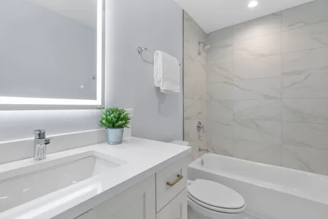 a bathroom with a sink a toilet a bathtub and shower