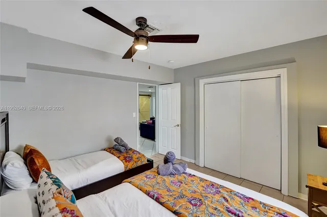 a bedroom with a bed a mirror and a large window with a potted plant