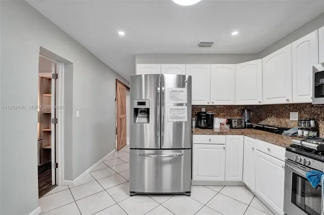 a kitchen with stainless steel appliances granite countertop a refrigerator stove microwave and sink