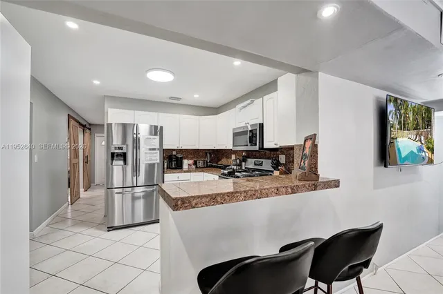 a kitchen with stainless steel appliances granite countertop a stove top oven a sink a counter top space and cabinets