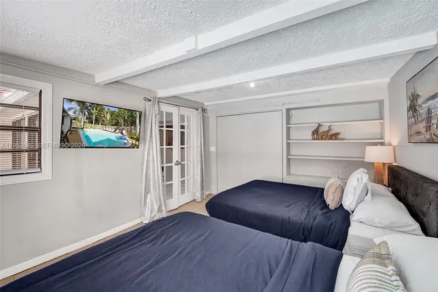 a bedroom with two beds and painting on the wall