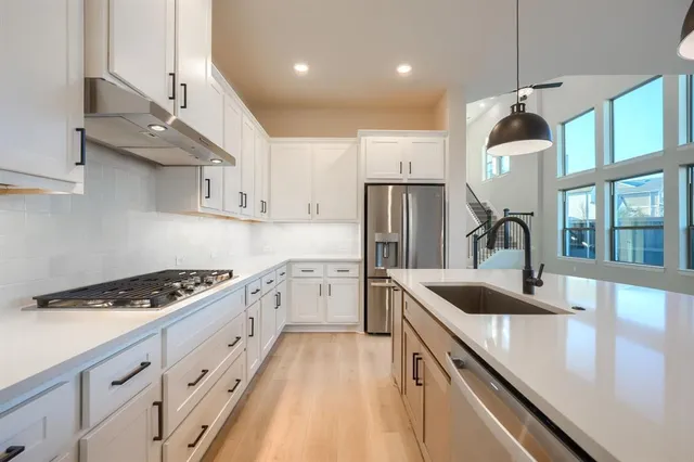 a kitchen with stainless steel appliances granite countertop a sink stove and refrigerator
