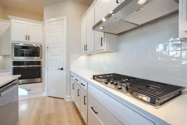a kitchen with stove and cabinets