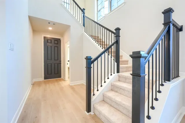 a view of a hallway with wooden floor and staircase