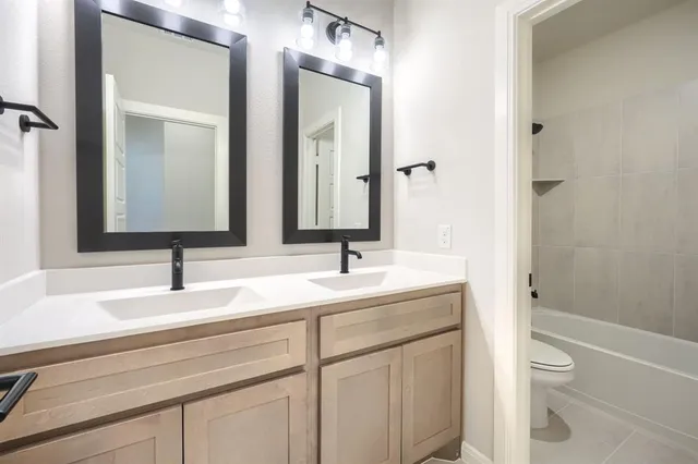 a bathroom with a sink a toilet and a mirror