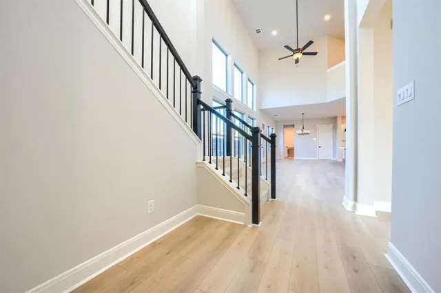 a view of a hallway with wooden floor and staircase