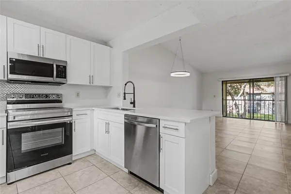 a kitchen with cabinets stainless steel appliances and a counter space