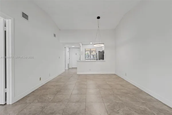 an empty room with windows and cabinet