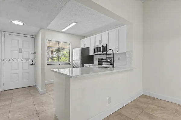 a kitchen with kitchen island a sink appliances and cabinets