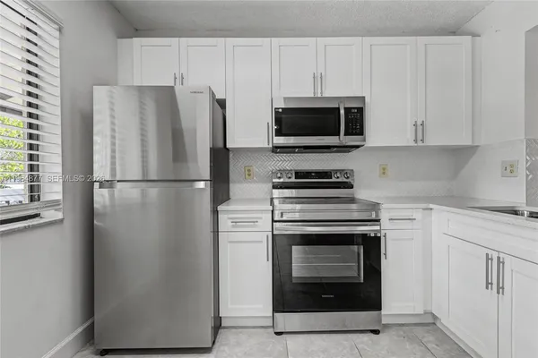 a kitchen with cabinets and stainless steel appliances