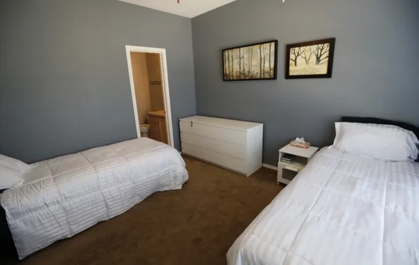 a bedroom with two beds and a lamp
