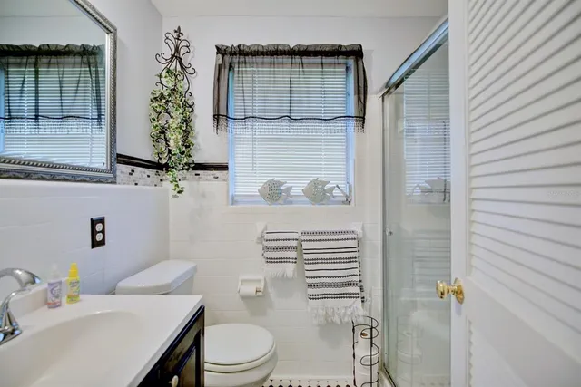 a bedroom with a bed a chandelier and a dresser