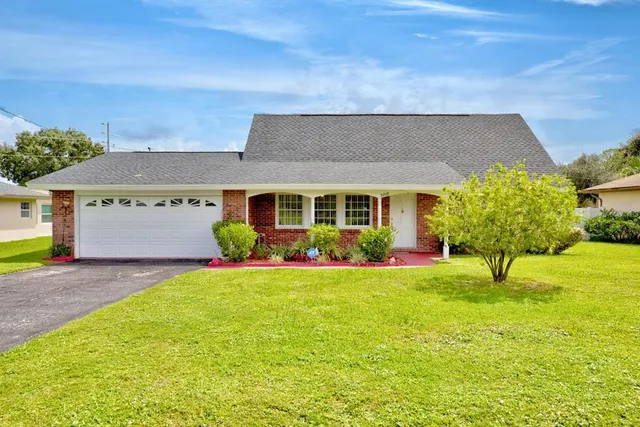 a view of a house with backyard and garden
