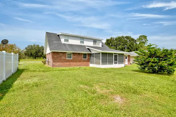 a backyard of a house with plants and wooden fence