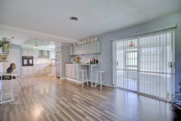 a view of a living room hardwood floor and a kitchen
