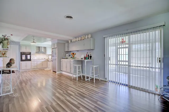 a view of a living room hardwood floor and a kitchen