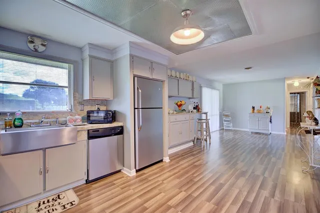 a kitchen with a refrigerator a stove and wooden floor