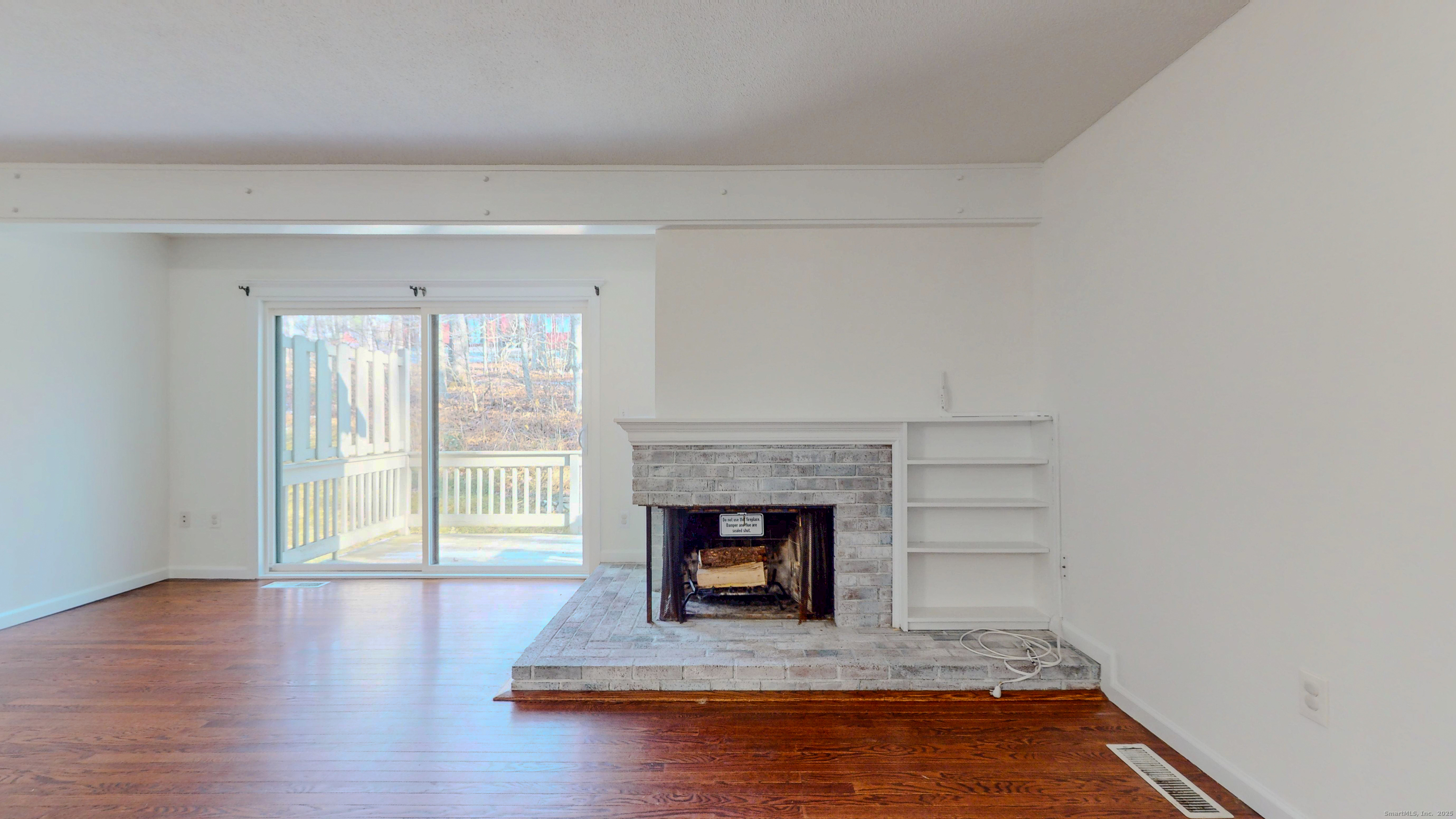 4 Fox Run, Unit 4 Woodbury, CT 06798 - Photo 6 of 25 a view of empty room with wooden floor and fireplace