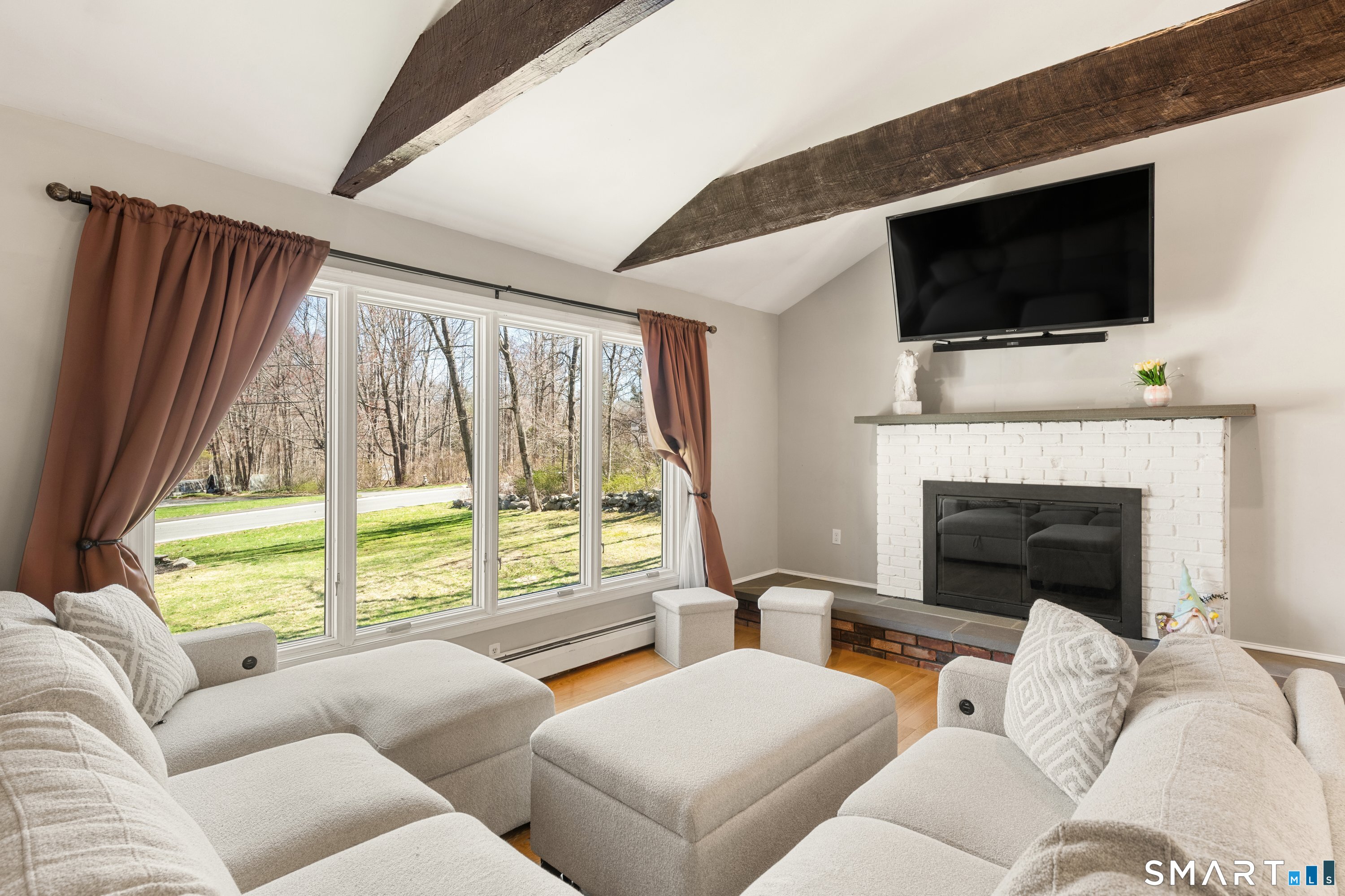 3 Pebble Road Newtown, CT 06470 - Photo 11 of 38 Sunny great room with striking beams, huge picture window, and fireplace- perfect spot to relax and enjoy the view year round!