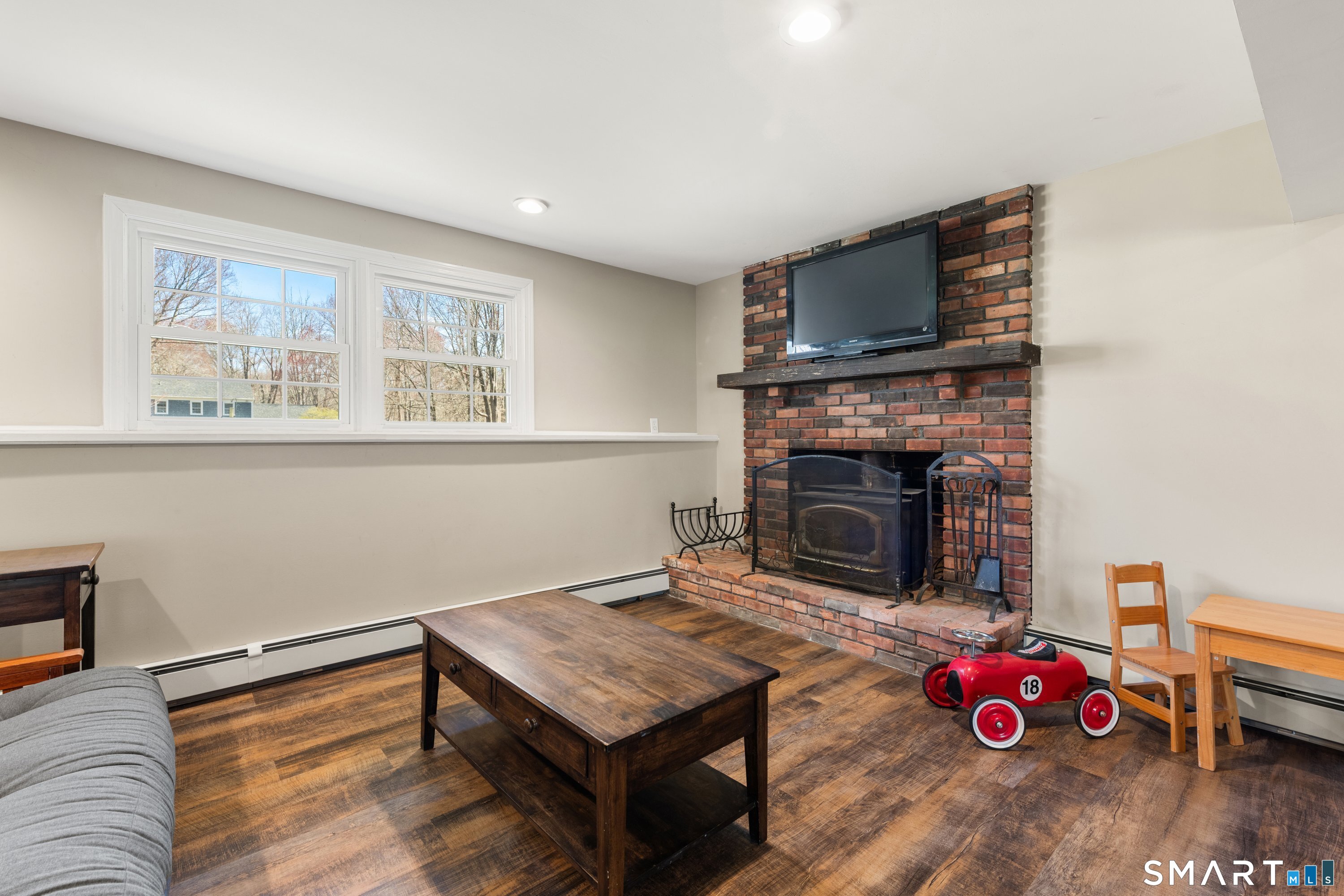 3 Pebble Road Newtown, CT 06470 - Photo 33 of 38 Lower level den with fireplace- wood stove does not convey.