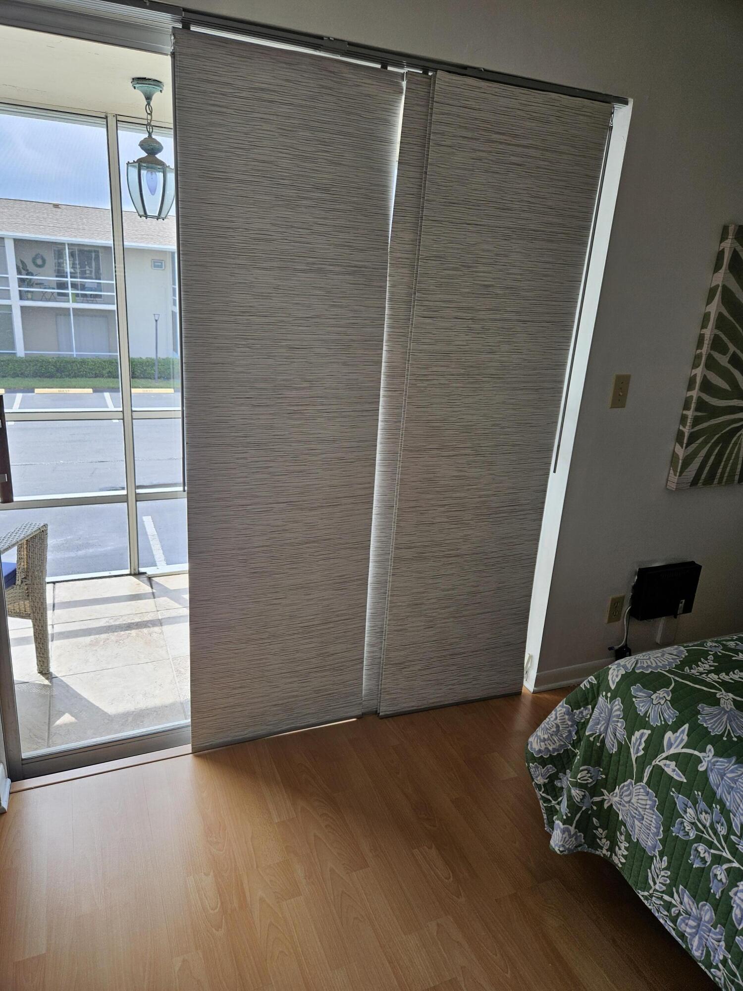 680 Horizon West, Unit 211 Boynton Beach, FL 33435 - Photo 5 of 6 a view of an empty room with wooden floor and a window
