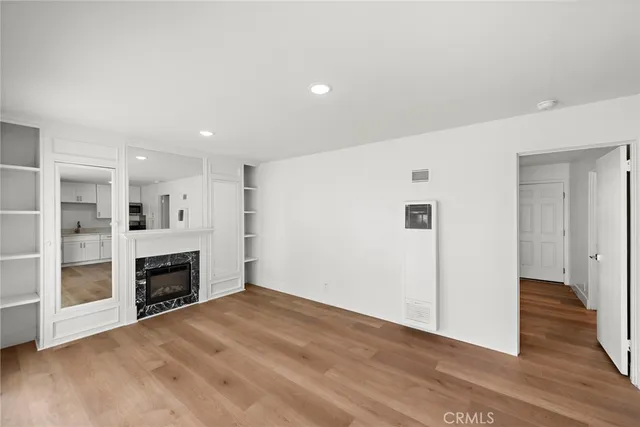 an empty room with wooden floor and fireplace