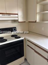4824 Southwest 152nd Court, Unit 32G Miami, FL 33185 - Photo 8 of 24 a kitchen with a stove and a white cabinets