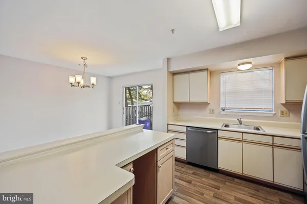 a kitchen with a sink and dishwasher with wooden floor