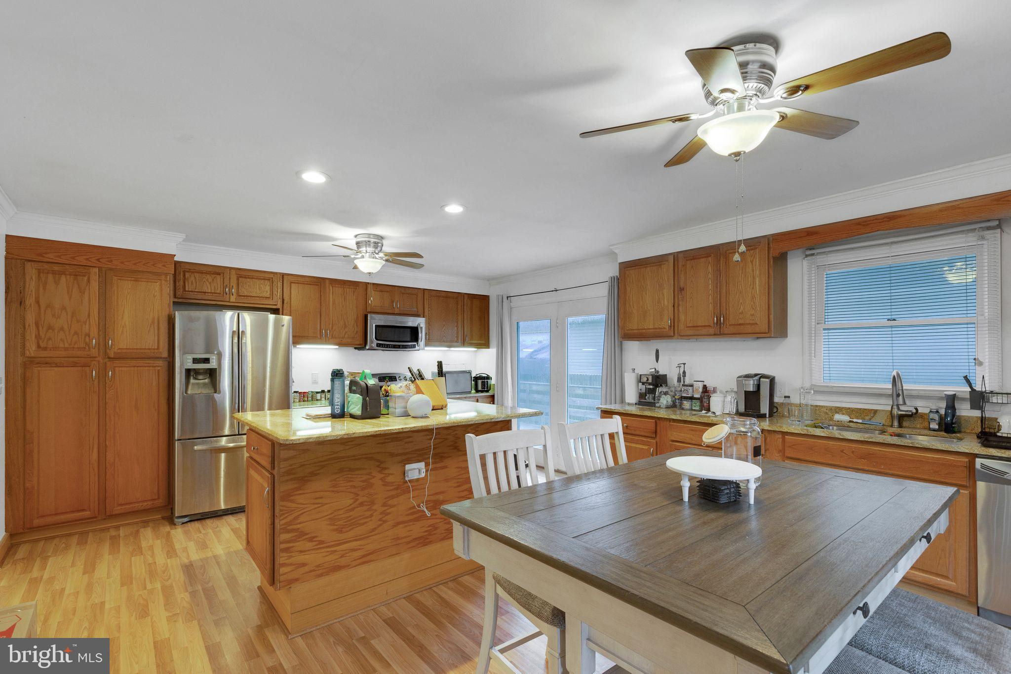 128 7th Street Colonial Beach, VA 22443 - Photo 12 of 32 a kitchen with a table chairs refrigerator and cabinets