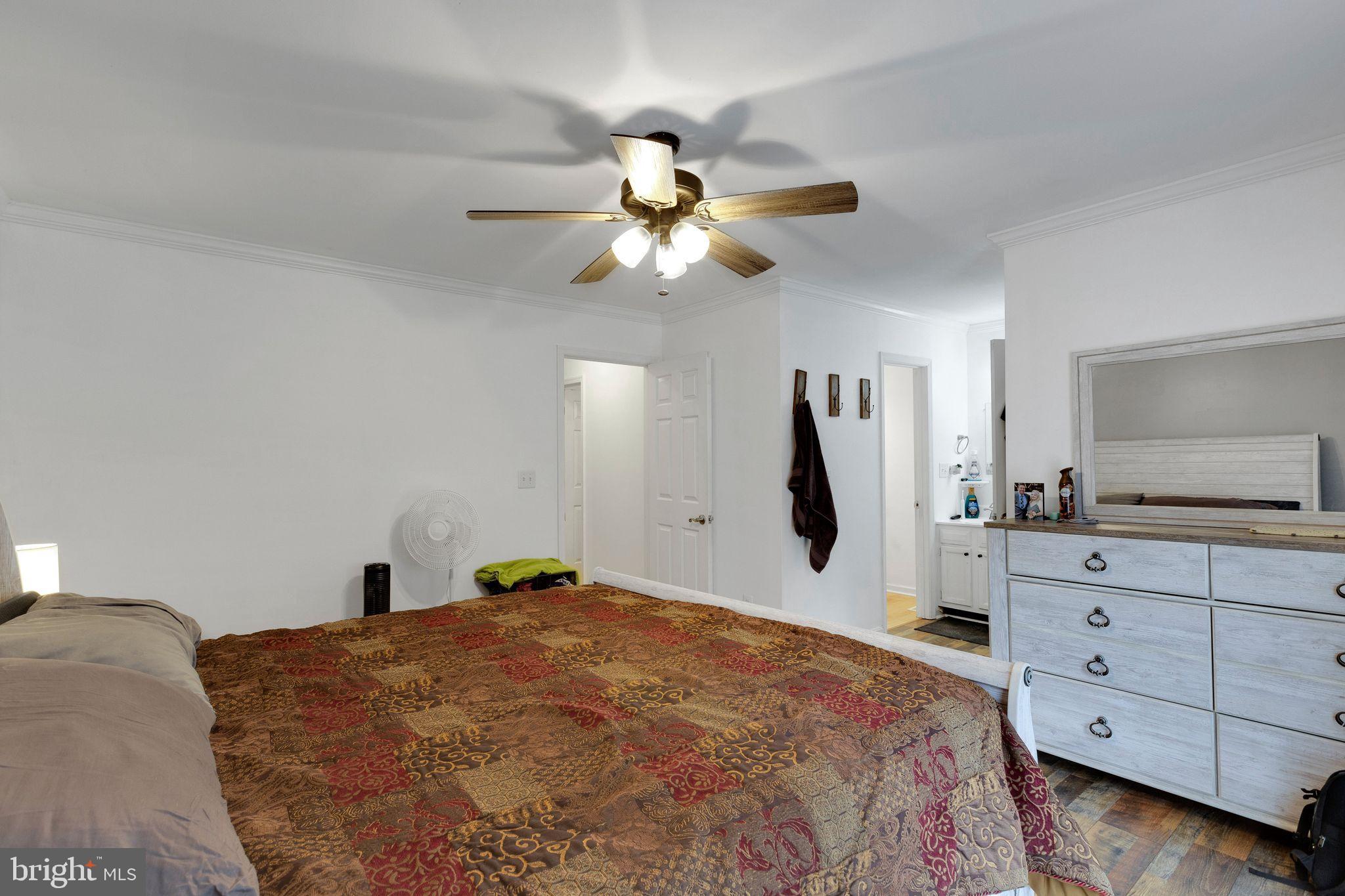 128 7th Street Colonial Beach, VA 22443 - Photo 16 of 32 a bedroom with a bed and a chandelier