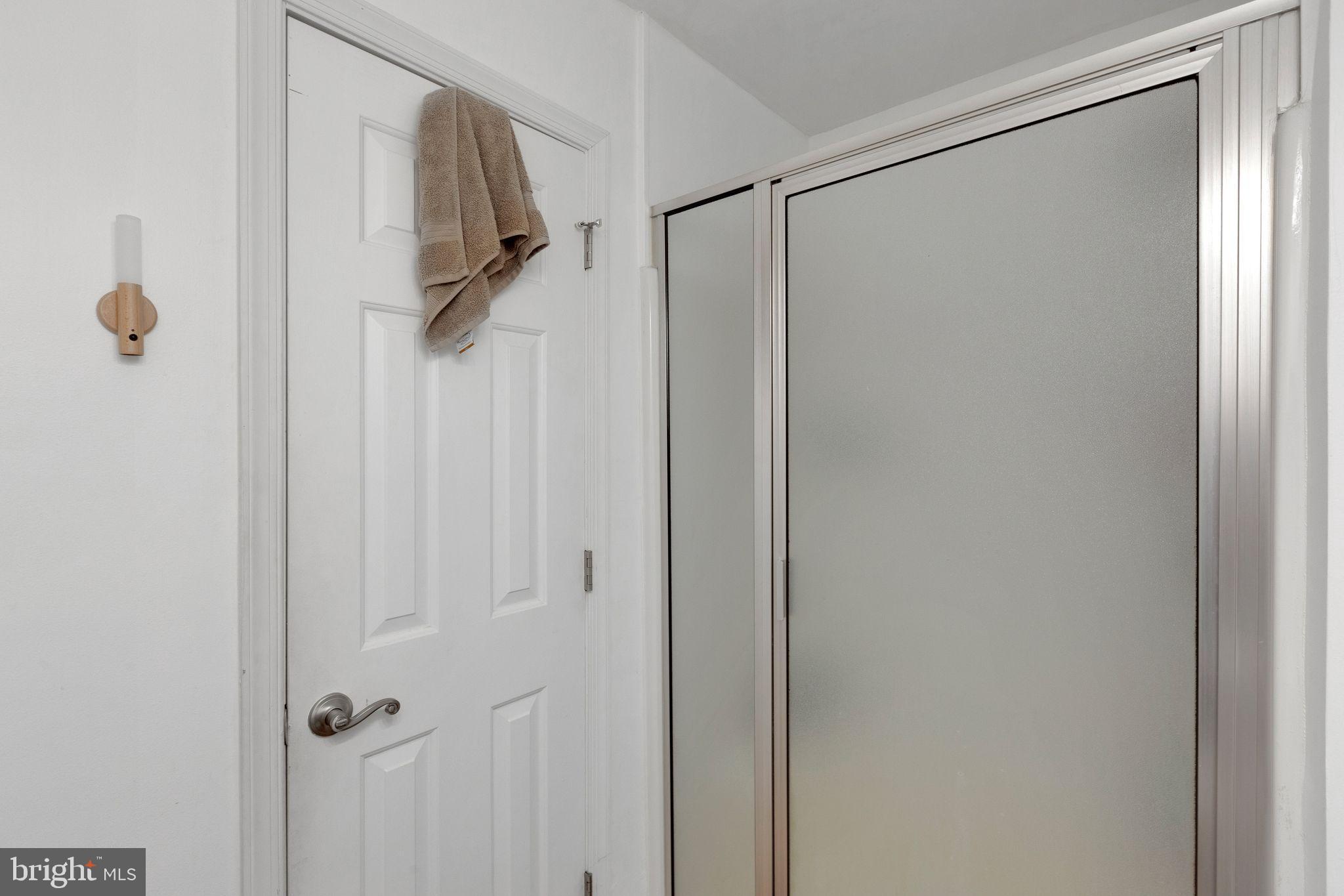 128 7th Street Colonial Beach, VA 22443 - Photo 19 of 32 a bathroom with a glass shower door